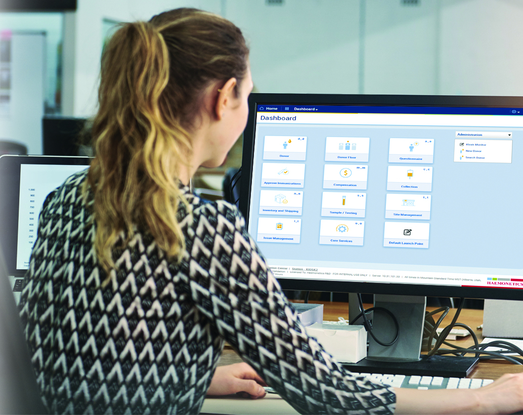 User in front of desktop showing NexLynk DMS application